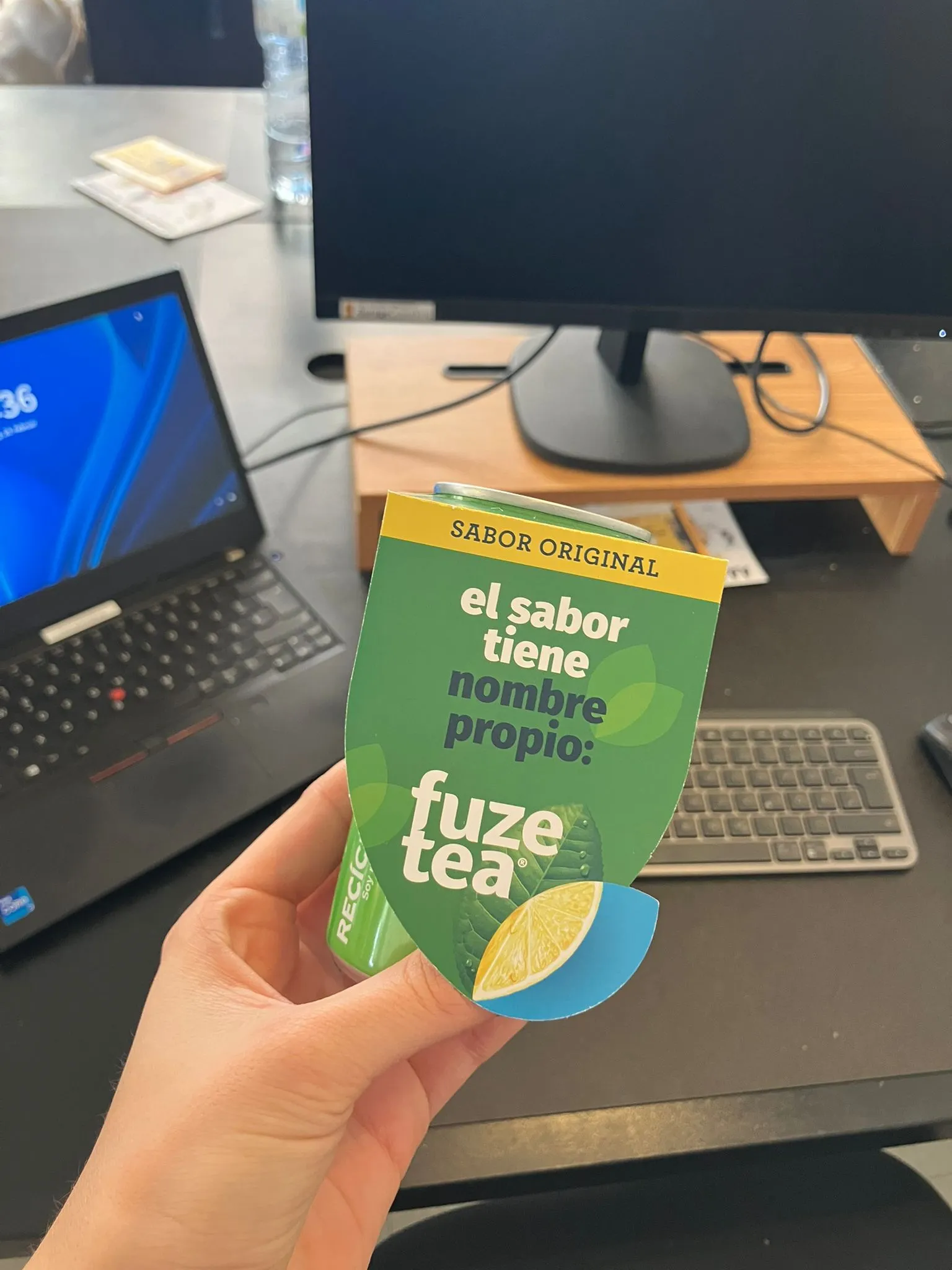 Lata de Fuze Tea con su etiqueta promocional sobre una mesa de oficina