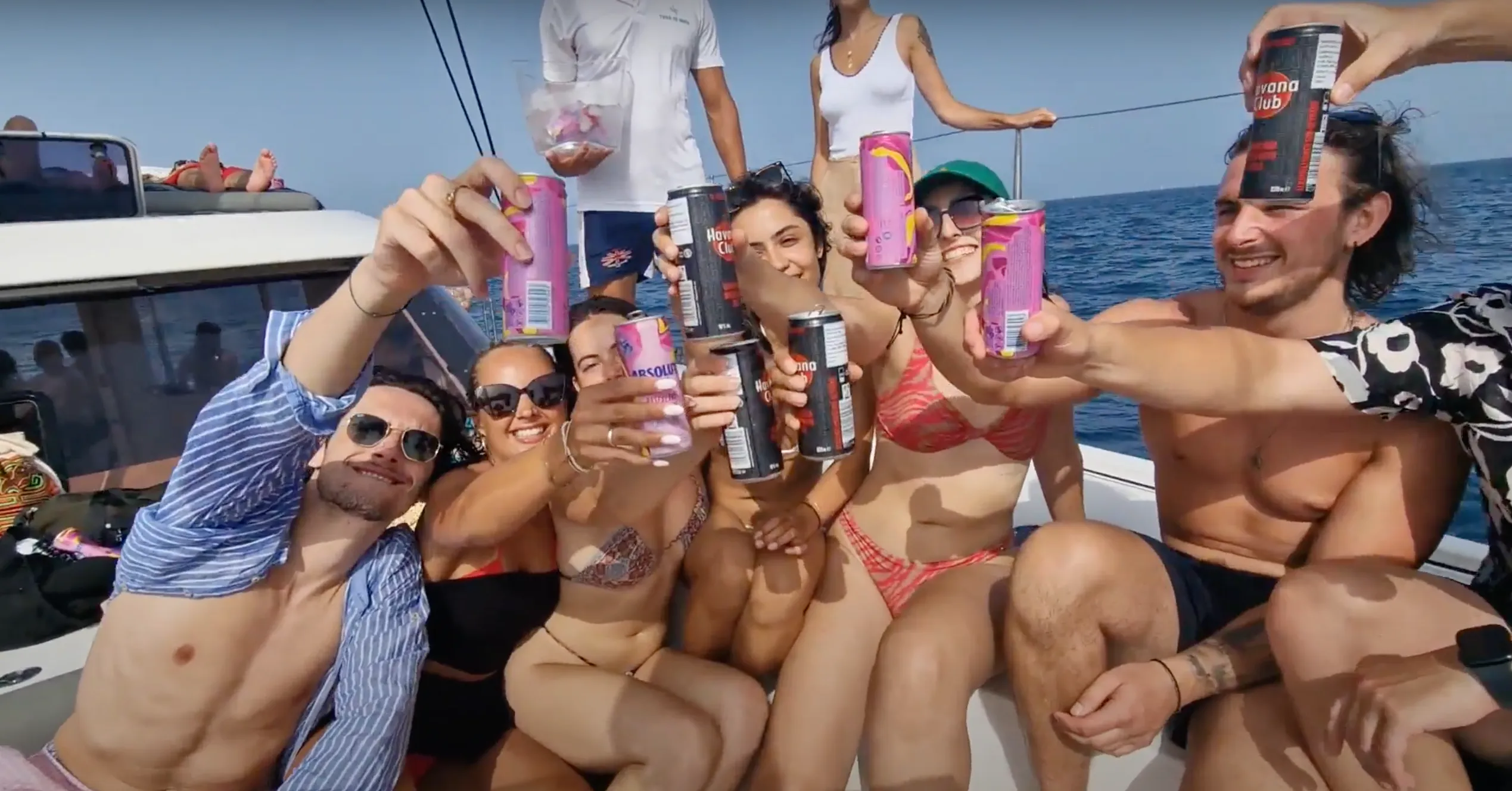 Grupo de amigos brindando con latas de Havana Club en un barco